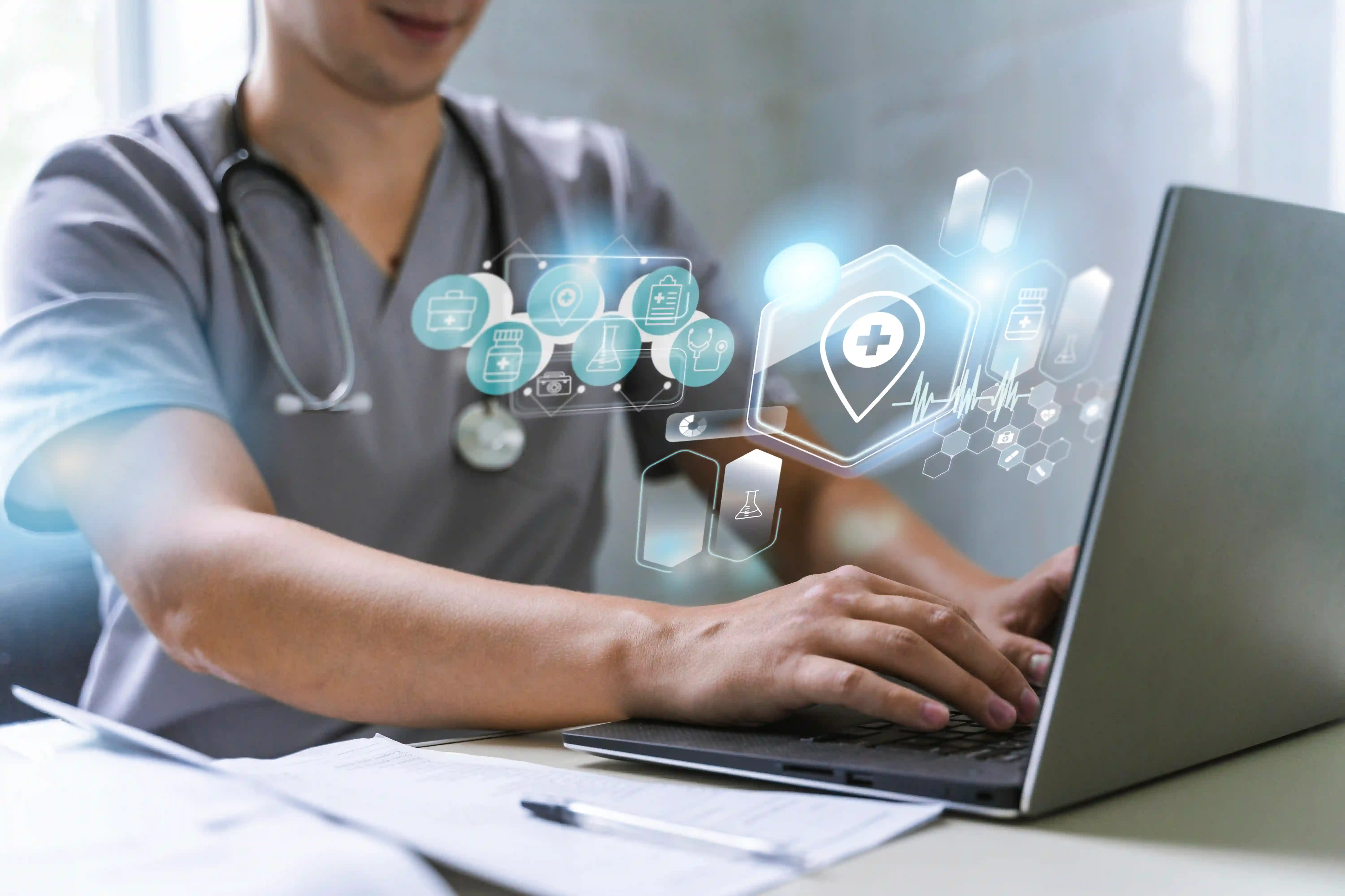 A healthcare professional in scrubs using a laptop, with digital icons including a health cross, microscope, and data symbols superimposed on the screen, representing medical technology or Hospital Information System data analysis. A stethoscope hangs around their neck.