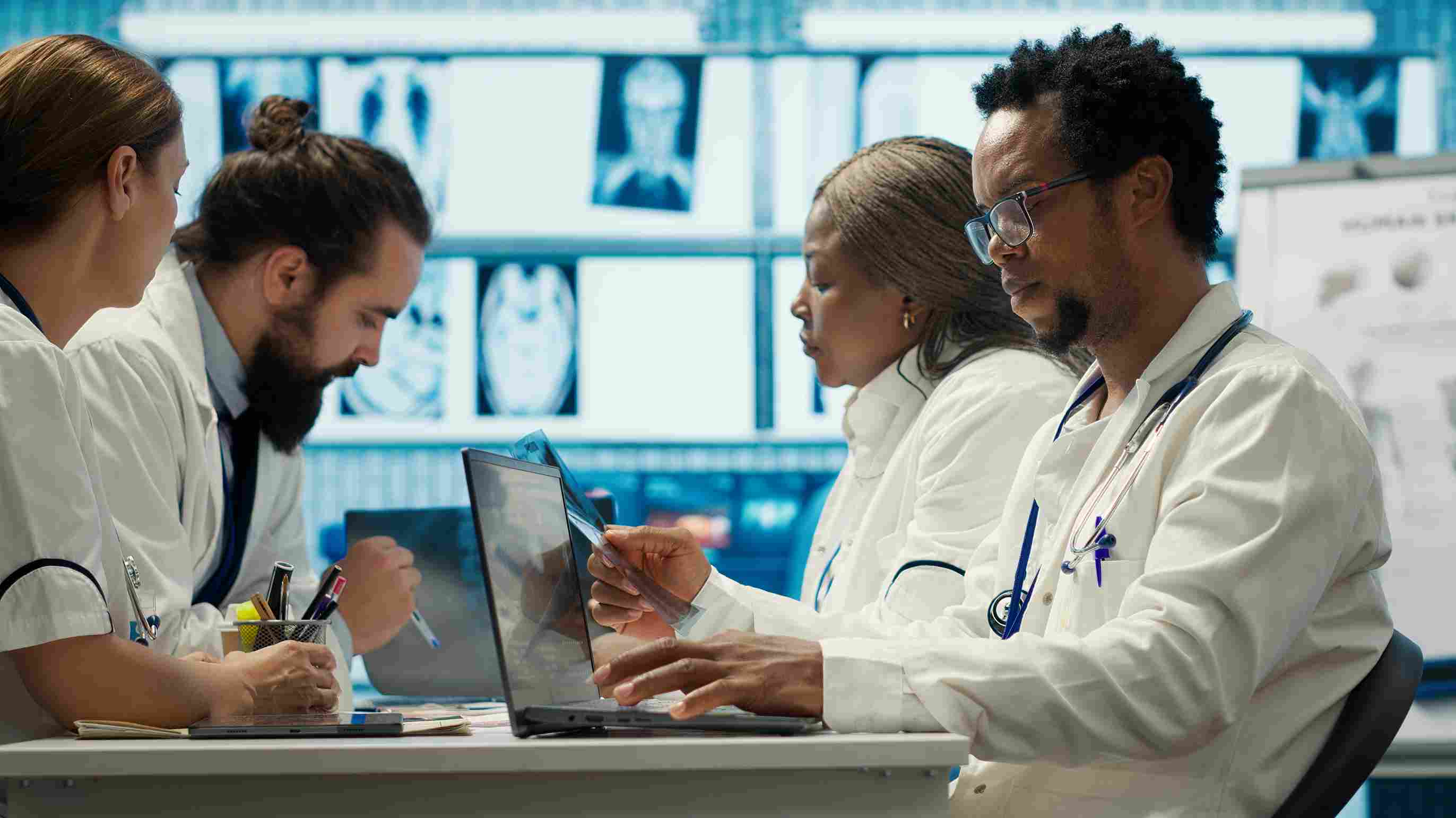 Doctors examining X-ray scans on a laptop with their hospital management system
