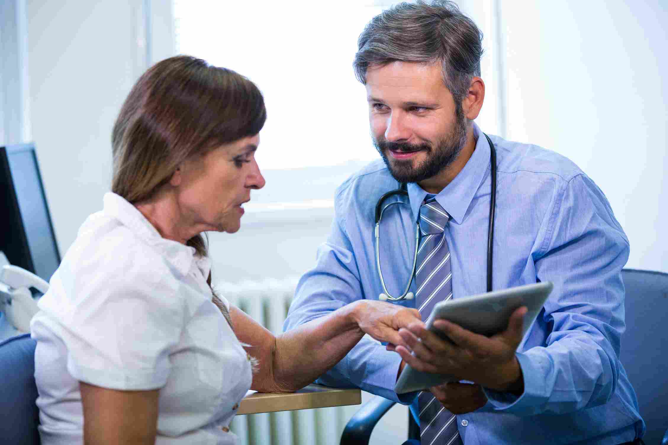 Doctor using a tablet to show patient data during a consultation.