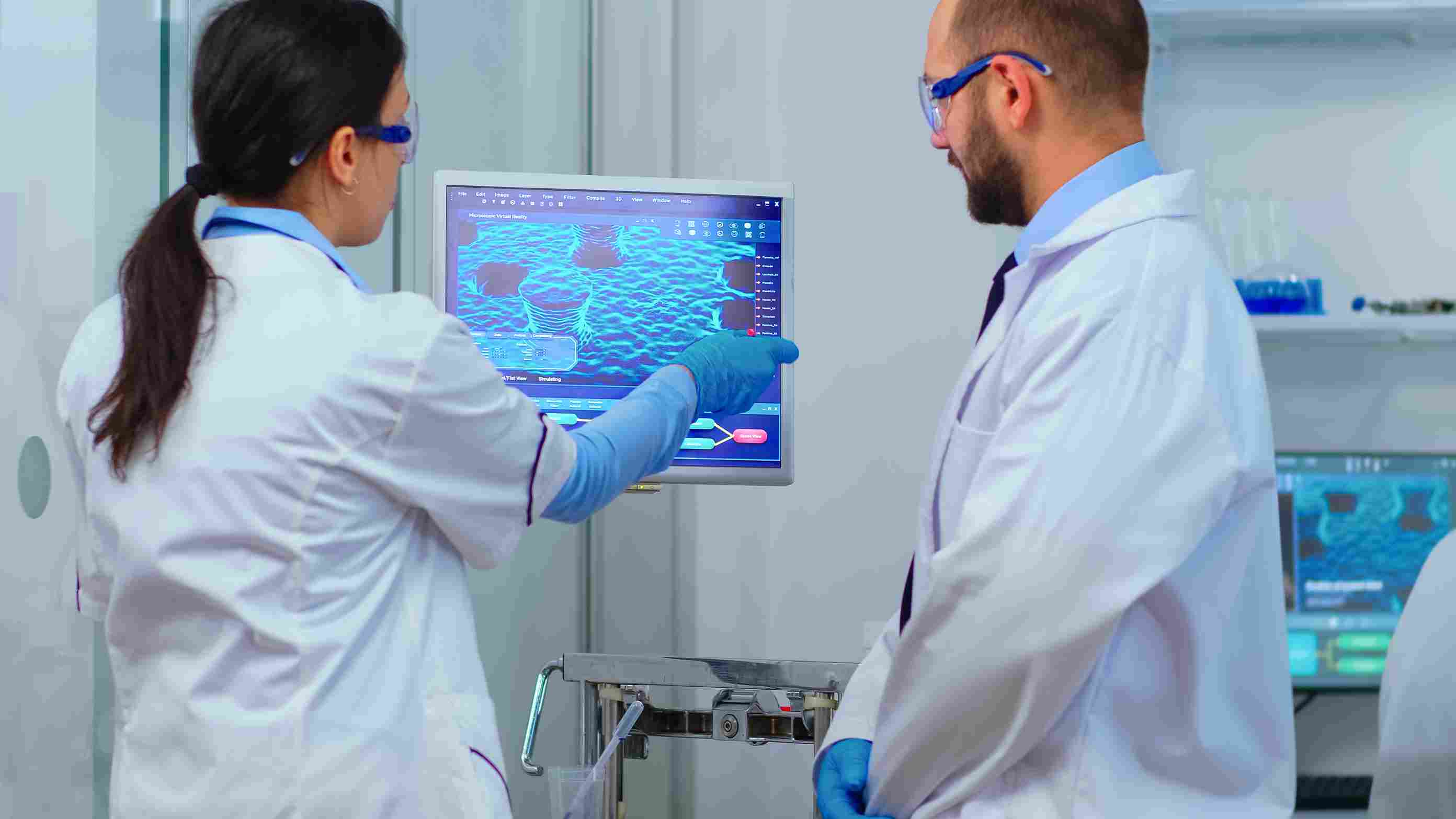 Lab scientists reviewing patient analytics via hospital management software