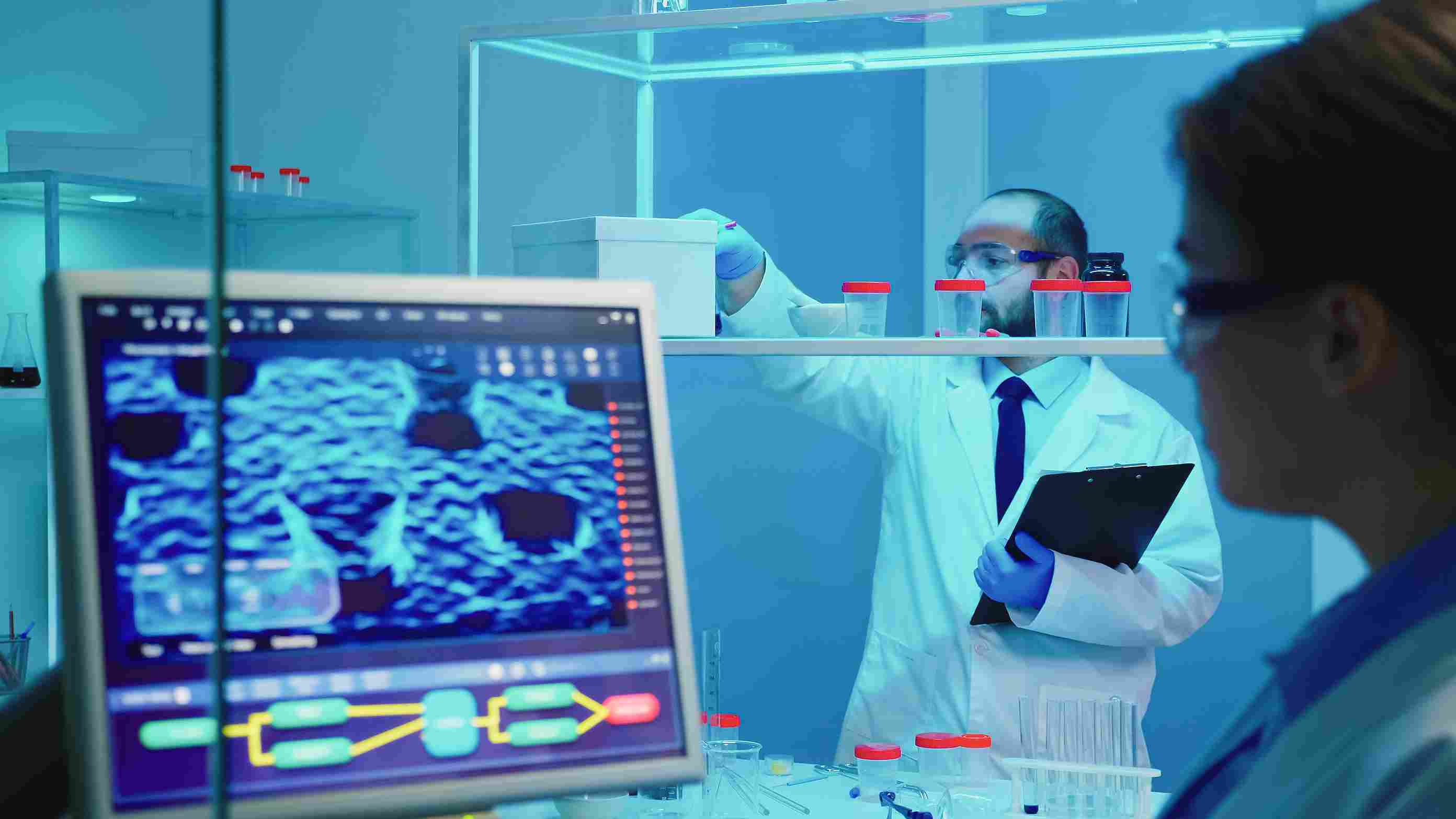 Healthcare professionals using hospital management software to analyze lab data in a modern research lab.