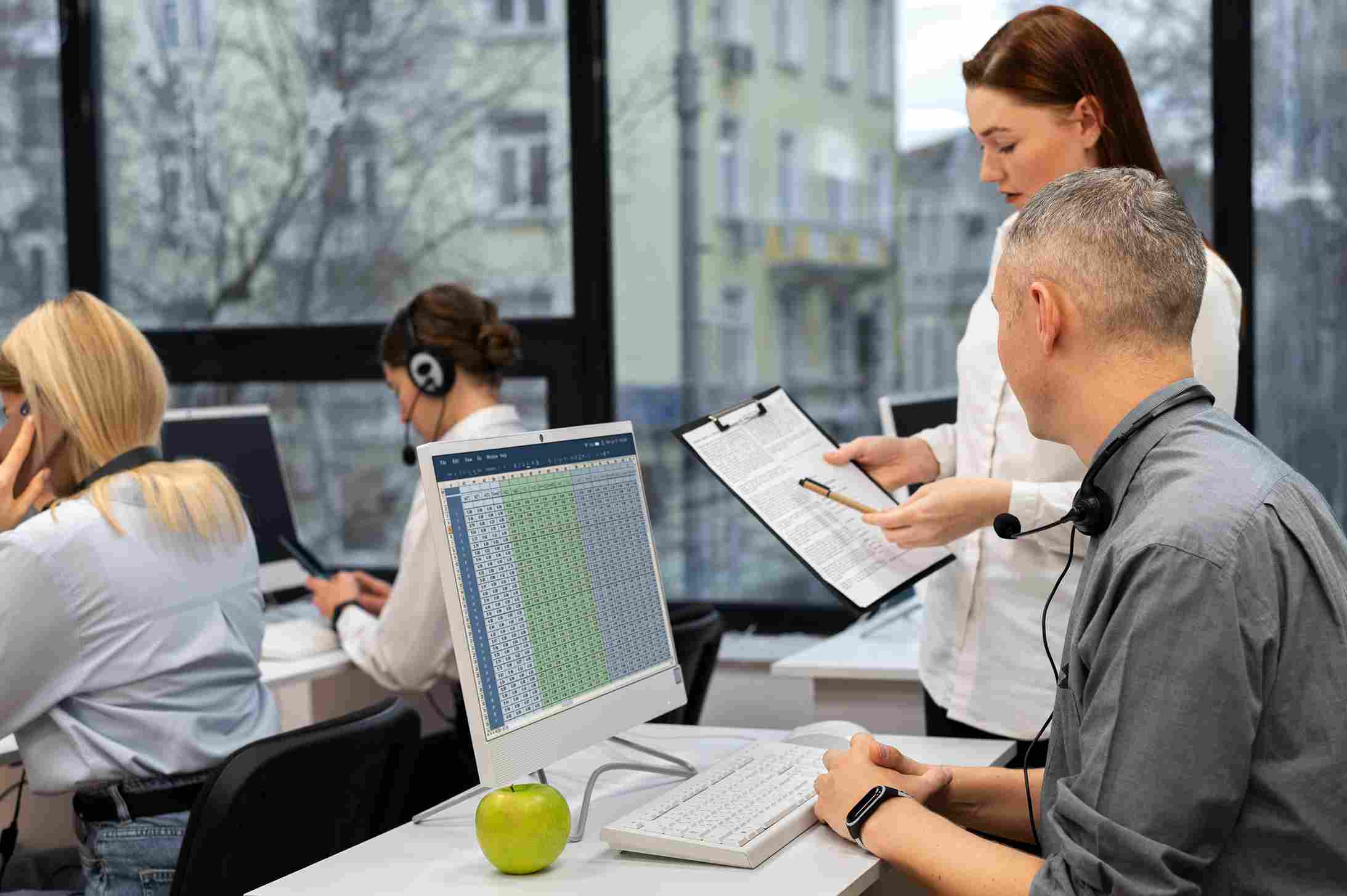 Support team collaborating with digital data on computer monitors in a hospital command center