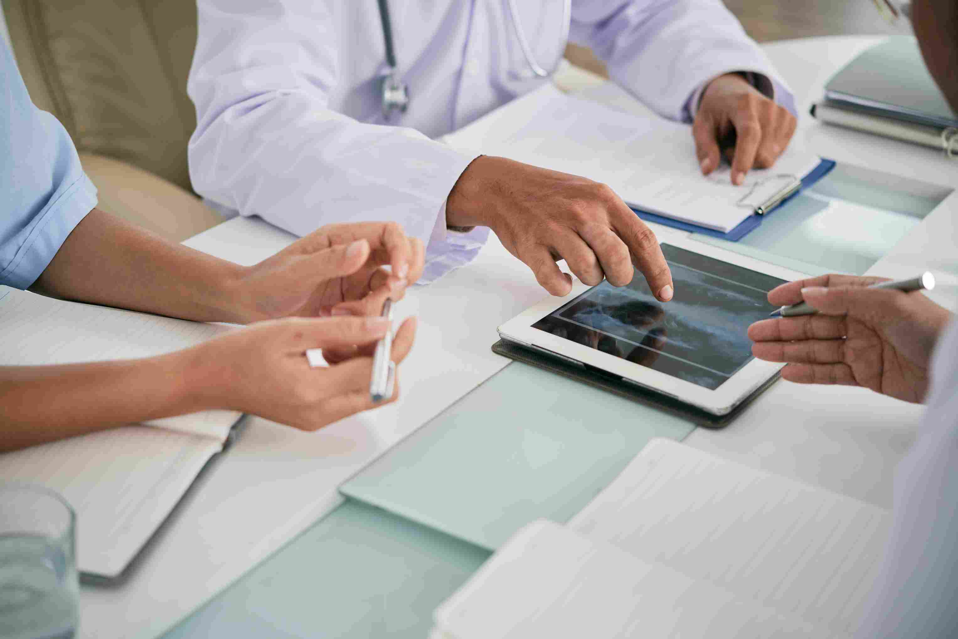 Medical professionals reviewing patient diagnostics on a tablet using a Hospital Information System