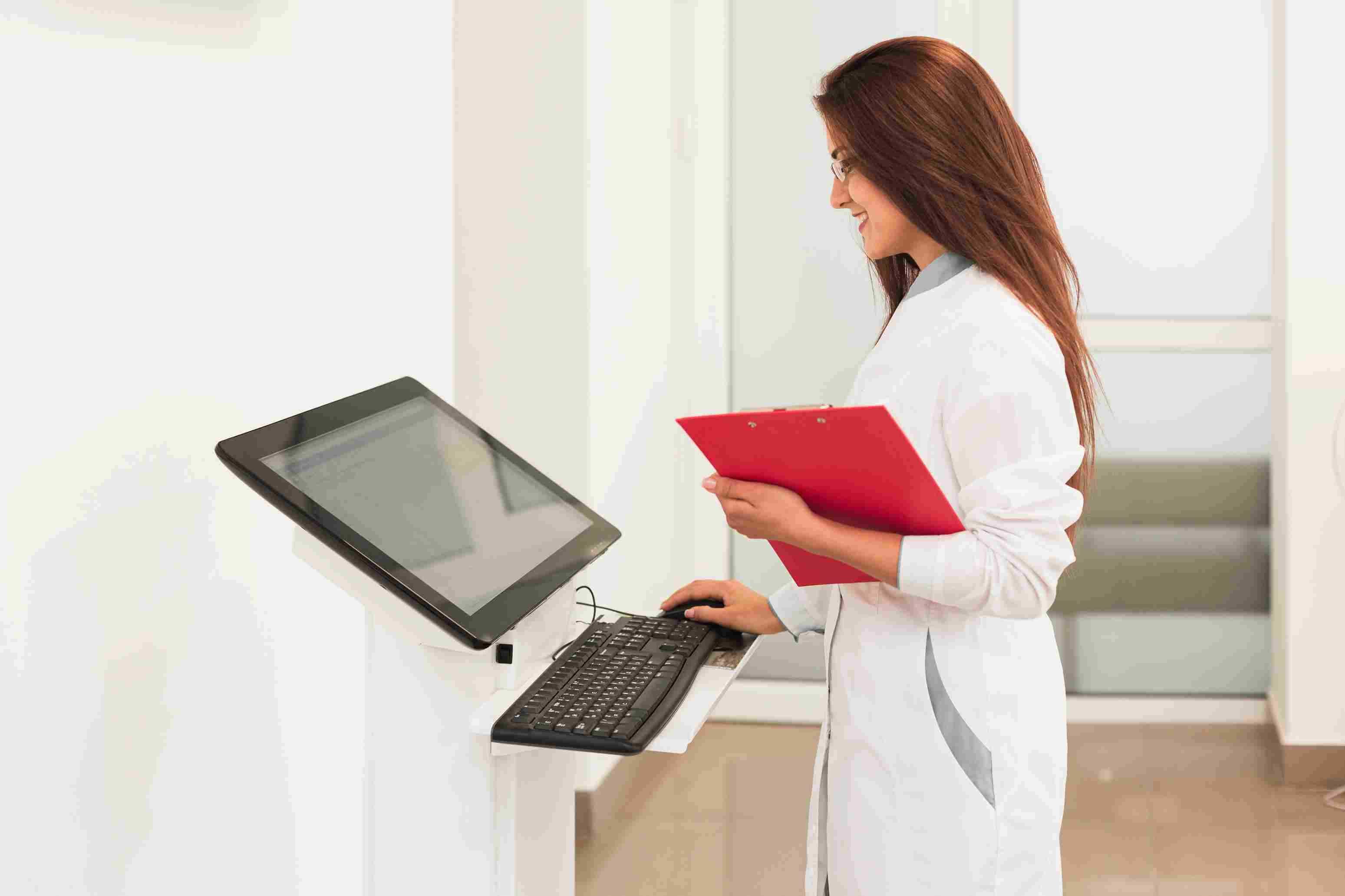 Female doctor accessing digital health records at a hospital kiosk through the Hospital Information System