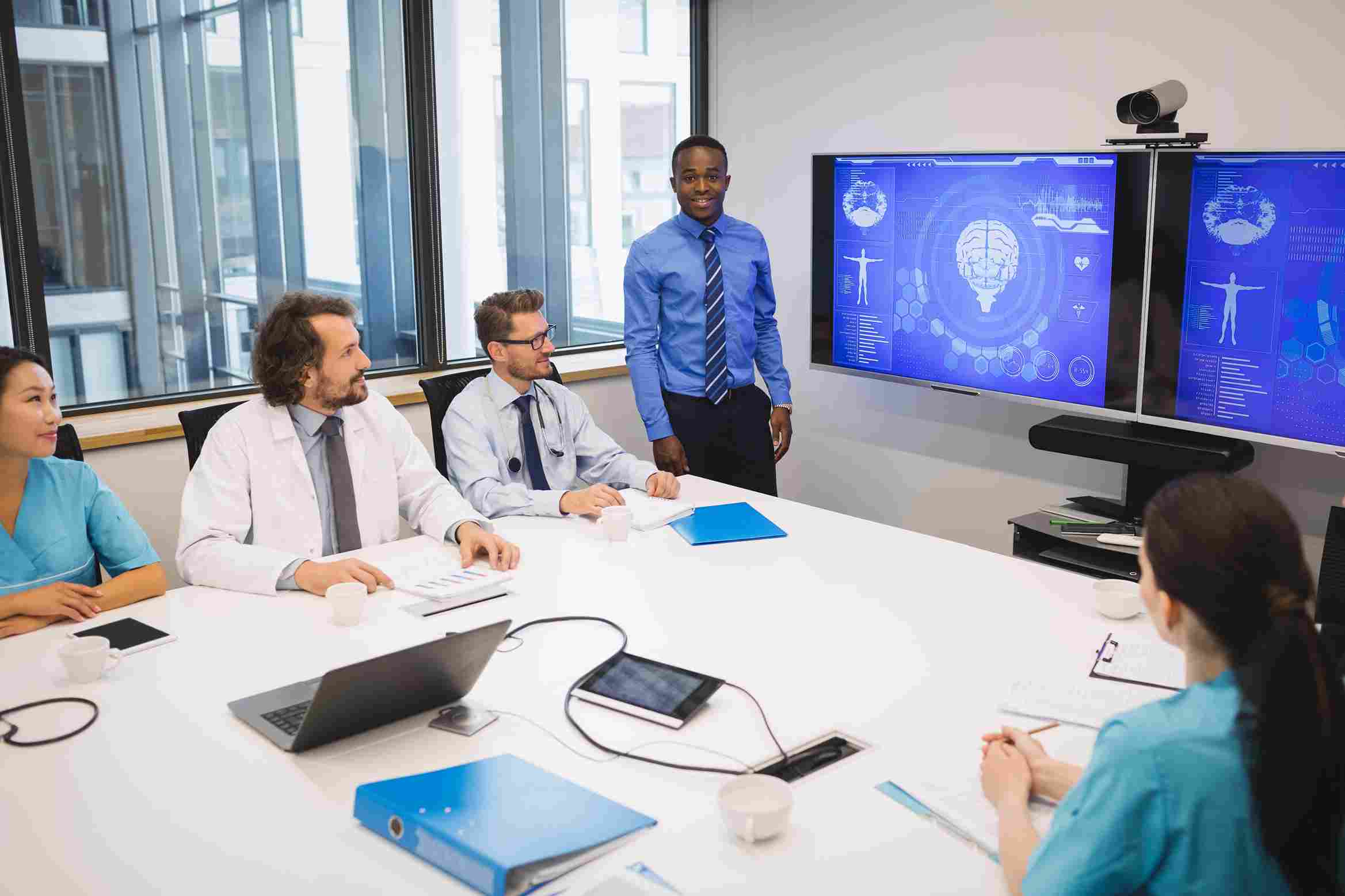 A doctor presenting medical data to a healthcare team, showcasing effective information exchange.