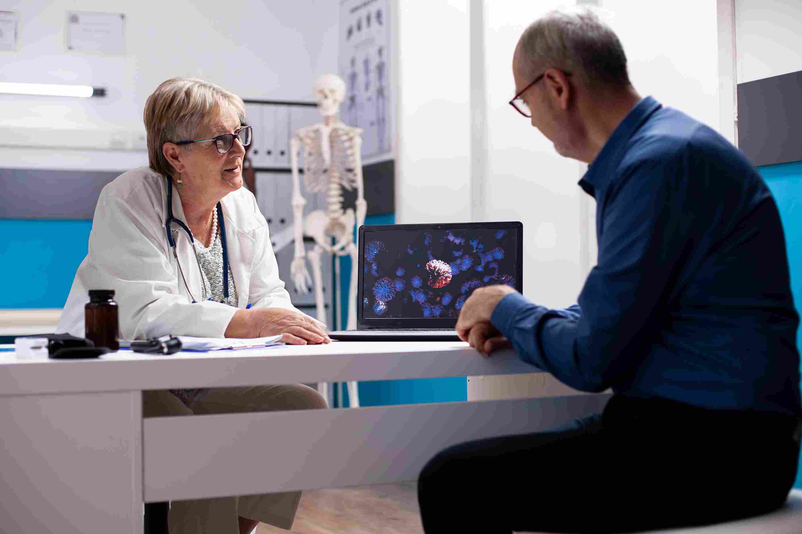Doctor discussing virus data with a patient using digital visuals, supported by interoperable hospital systems.
