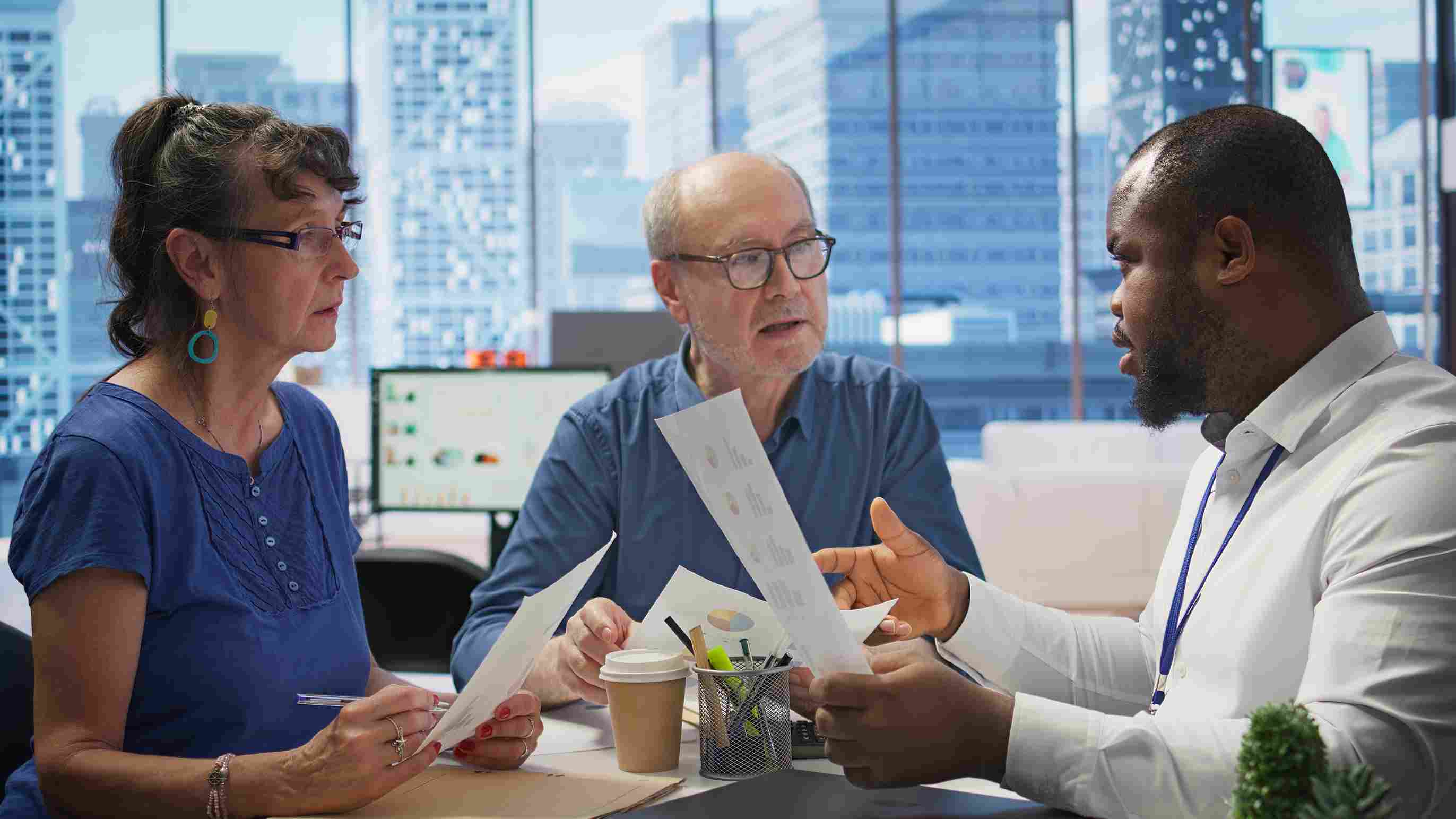 Senior couple consulting with a healthcare manager about patient data protection and GDPR rights in a modern hospital setting.