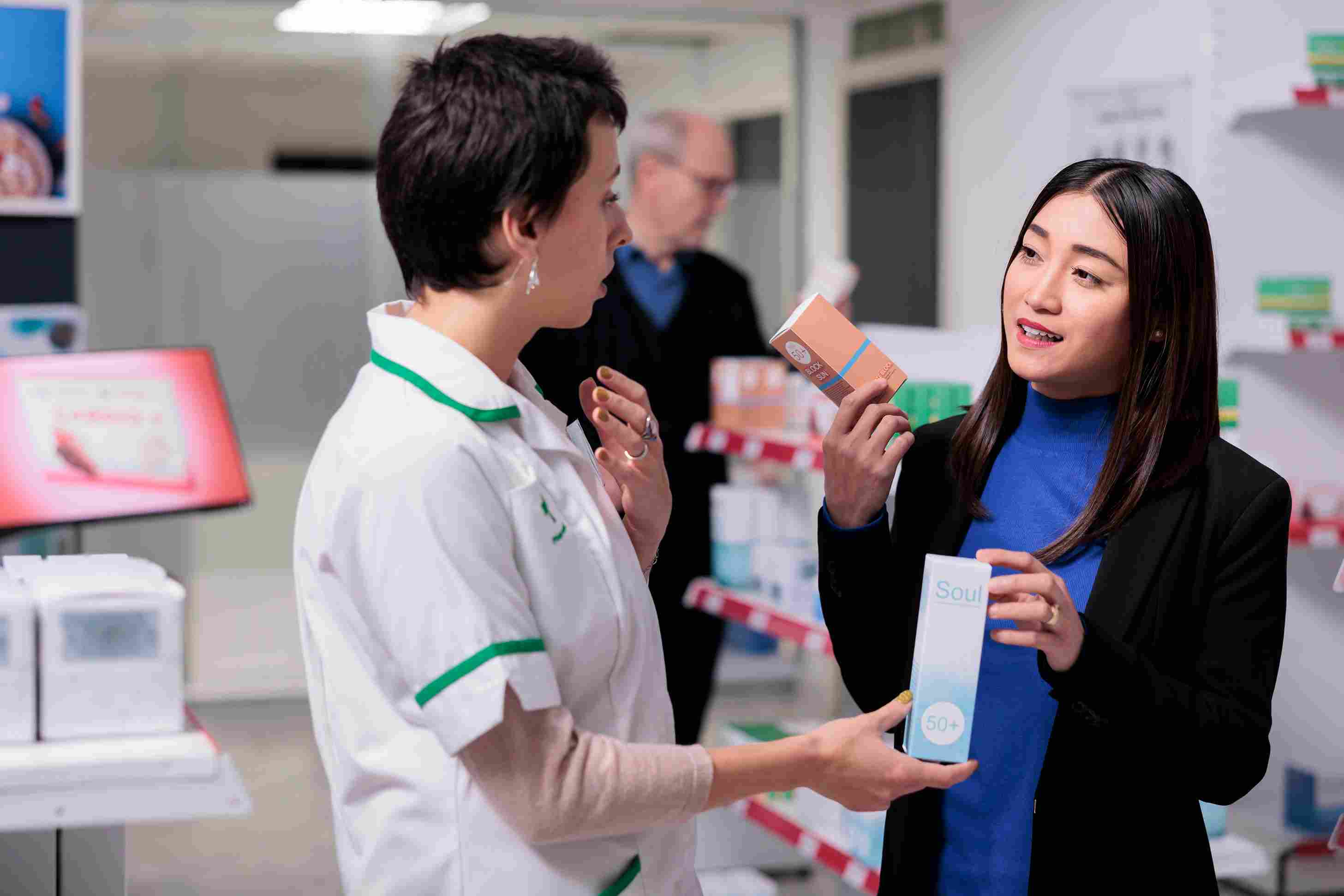 Pharmacist discussing product options with a woman in a pharmacy, highlighting how HMS enhances personalized care and informed medication choices.