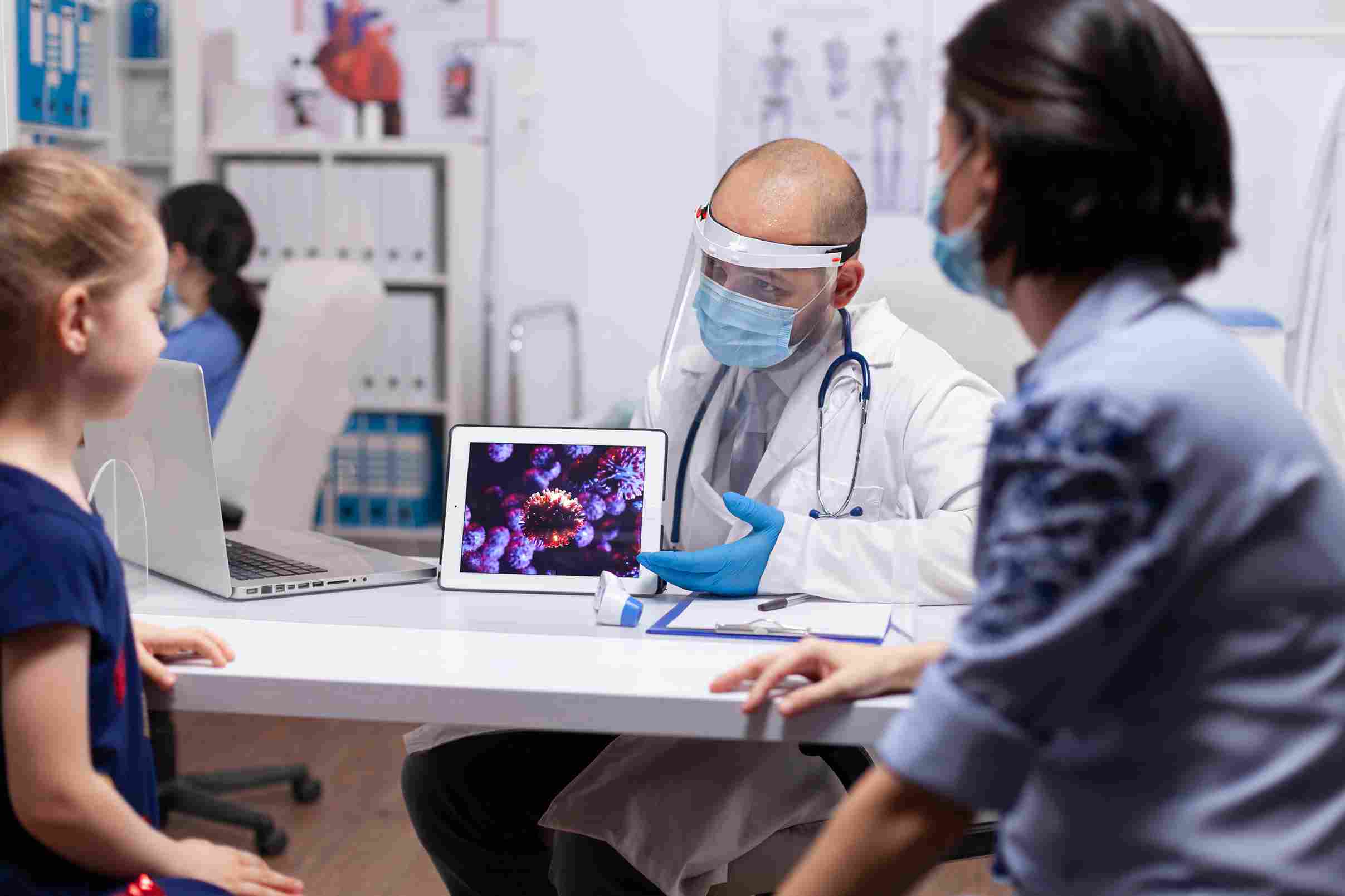 Medical specialist using a tablet to share pandemic-related insights via integrated healthcare systems.