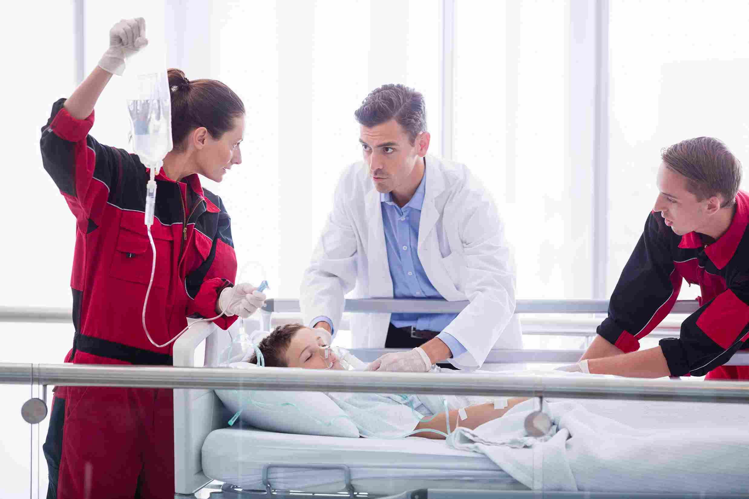 Healthcare team providing emergency treatment to a patient in a hospital corridor, reflecting the role of digital systems in improving clinical efficiency