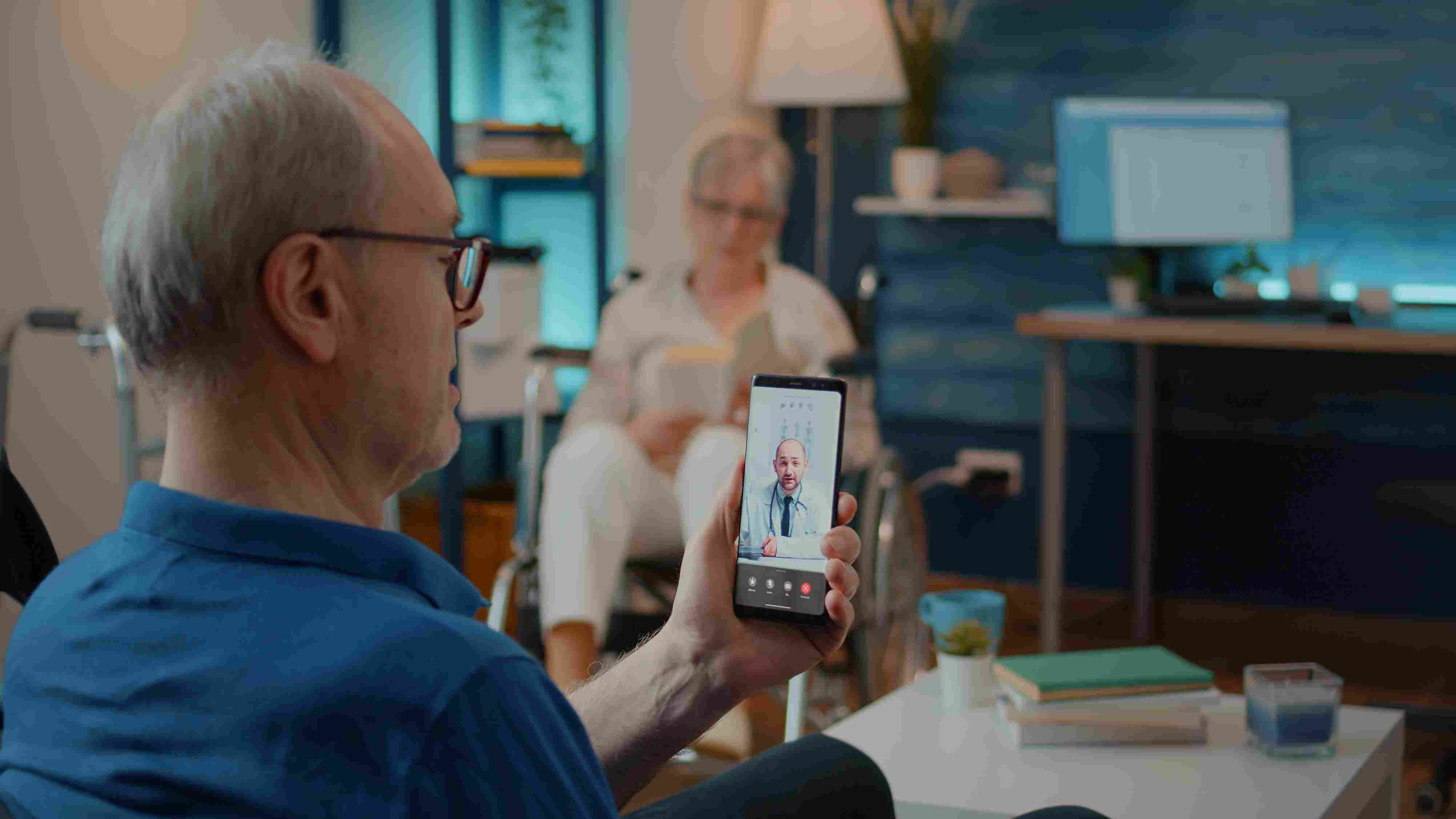 Elderly man using a mobile health app for a video consultation with his doctor, showcasing how mobile apps improve patient engagement and accessibility in healthcare.