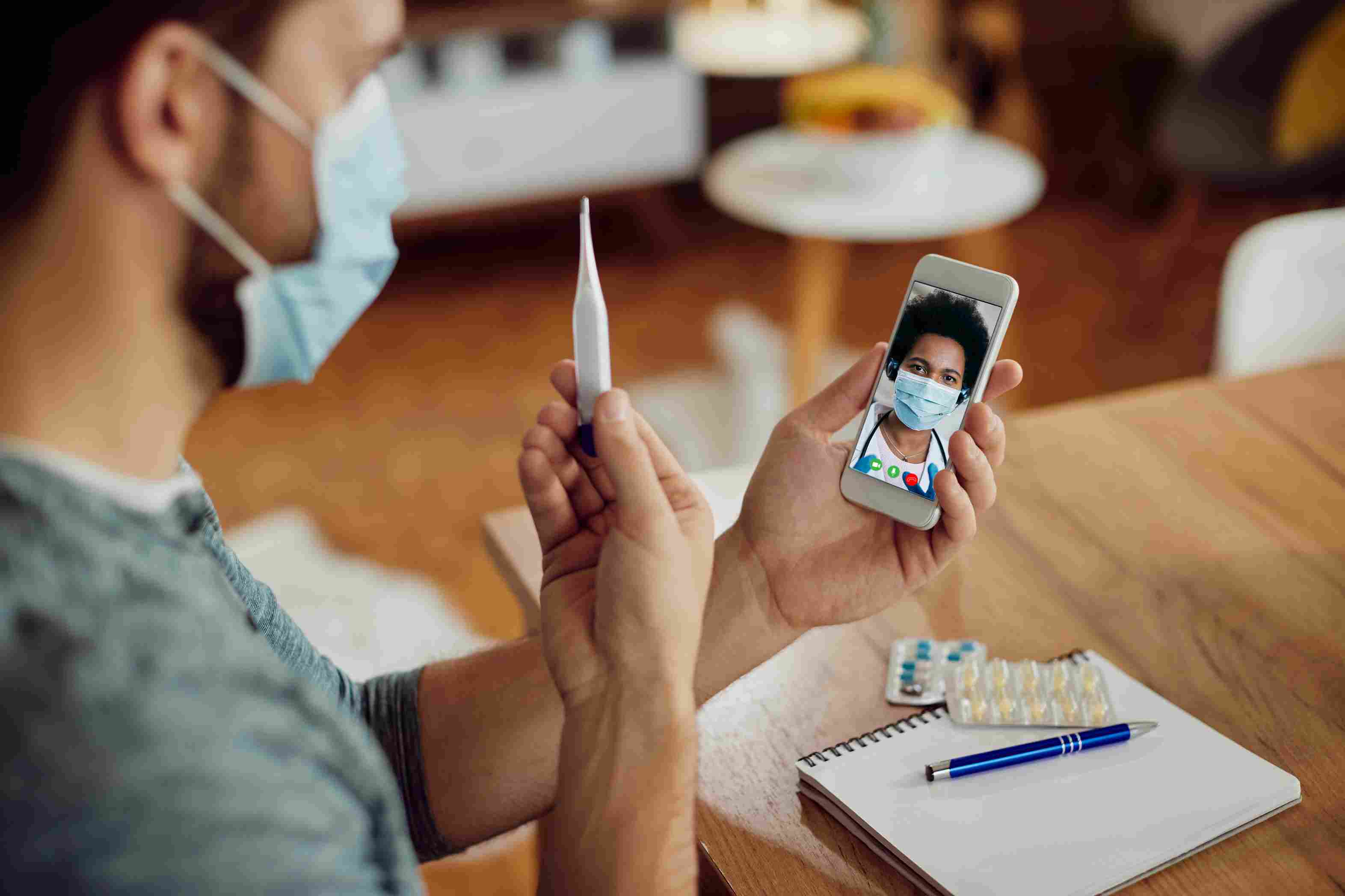 Father and daughter consulting a doctor via a mobile app during a telehealth session, highlighting the role of mobile apps in direct communication and timely care.
