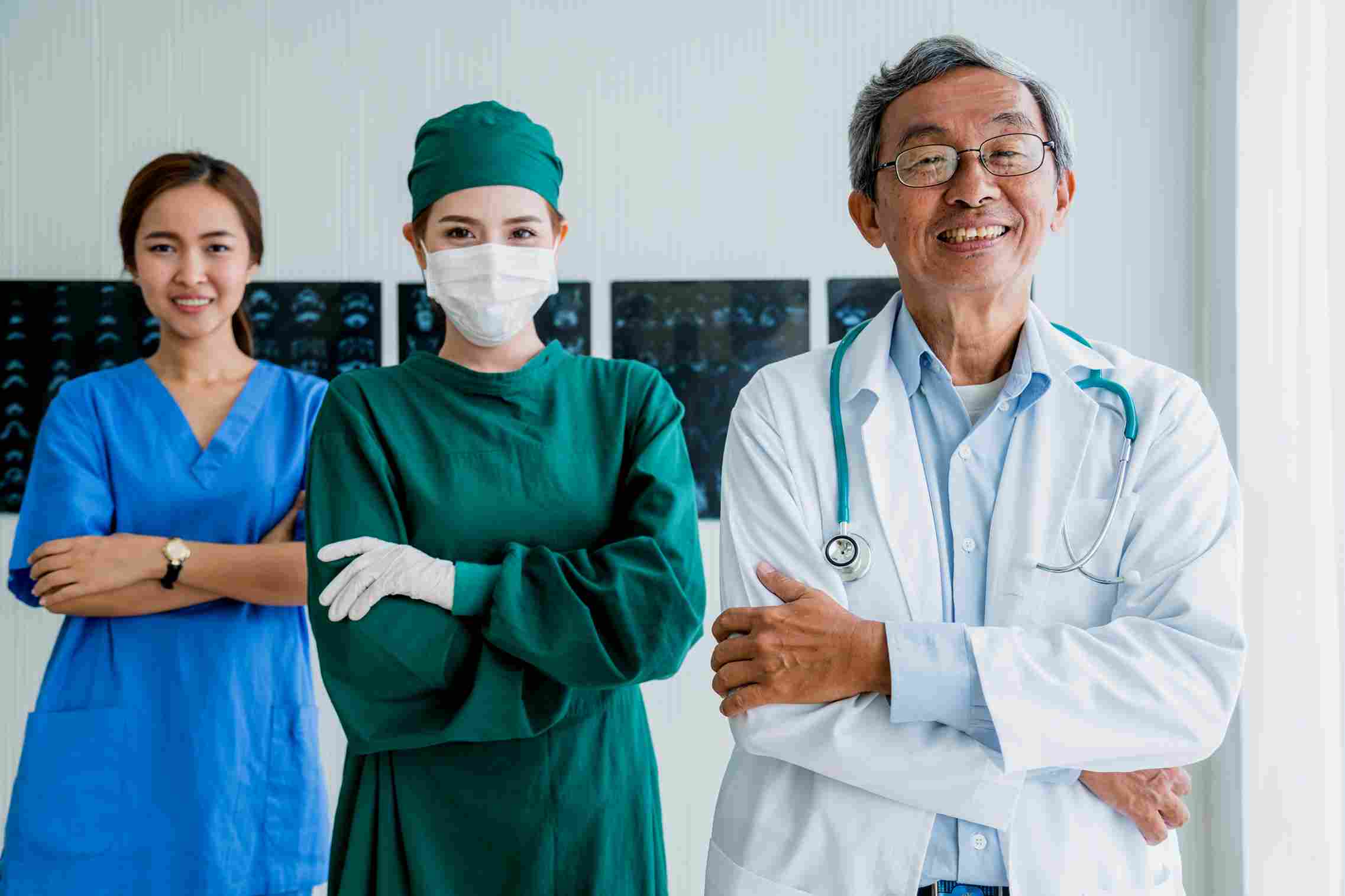 Smiling doctors and nurse standing confidently together in a hospital, symbolizing teamwork and dedication in Indonesia's BPJS Kesehatan healthcare system